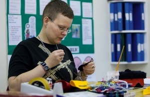 Student at further education college sewing at a table