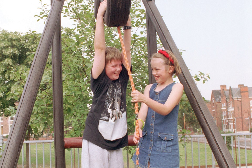 Two children talk to each other in a playground