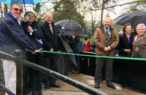 Group of people behind a green ribbon across a flood gate in Totnes