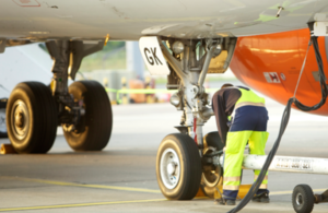 Ground crew working below a passenger airplane and refueling