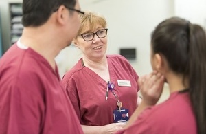 Close-up of 3 nurses chatting.