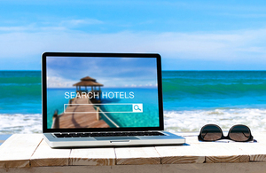 Laptop on a beach with hotel booking website on display