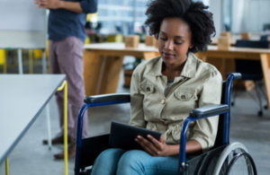 Woman in a wheelchair holding a tablet