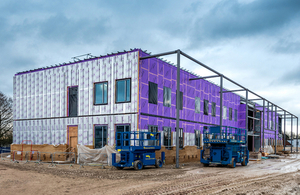 Regimental Headquarters and Lodger Units in mid-construction at Worthy Down. The purple building is surrounded with scaffolding.