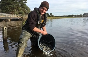 Image shows Nick Gill releasing fish into Lockwood Beck