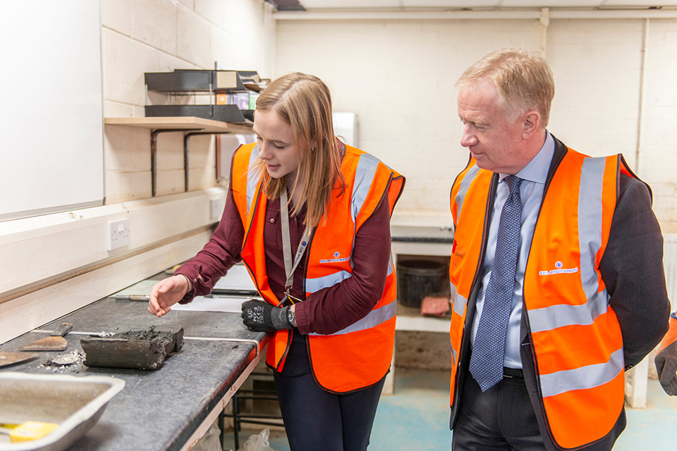 Postgraduate placement engineer, Emma, demonstrates sampling methods to Mark.