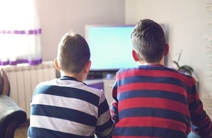 Two boys sitting in front of television