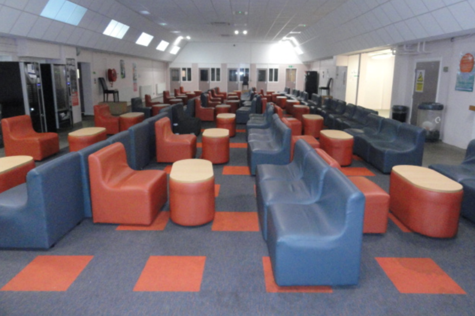 Photograph of Wetherby's open plan visiting hall with comfy seats, carpet and low tables.