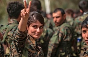 A female fighter of the US-backed Kurdish-led Syrian Democratic Forces (SDF) flashes the victory gesture while celebrating near the Omar oil field in the eastern Syrian Deir Ezzor province on March 23, 2019