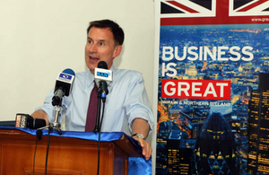 Jeremy Hunt speaking at an event in Nigeria, with a 'Business is GREAT' banner behind him,