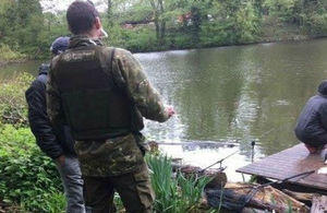 Environment Agency fisheries officer speaking to anglers on a fishing platform