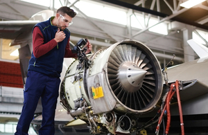 An engineer works on an aircraft turbine.