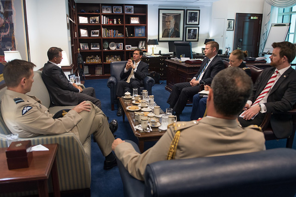 Service personnel in a meeting room chatting with Dr. Mark T. Espern at the Pentagon. 
