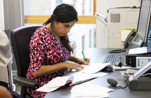 A doctor writing up notes at her desk.