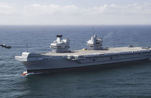 Two F-35B Lightning II fighter jets landing on HMS Queen Elizabeth out at sea.