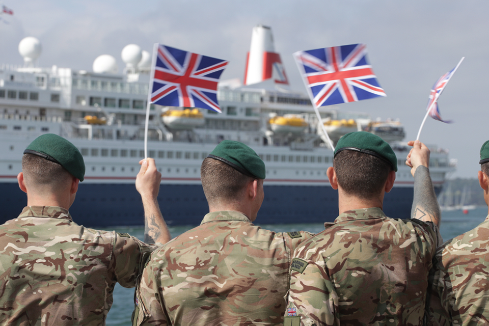 A group of Royal Marines are pictured waving Union Flags as the ship, the MV Boudicca, departs Poole Harbour. The ship is carrying around 300 veterans as part of a nine-day commemorative tour.