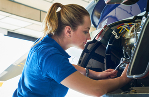 A female engineer works on a plane turbine.