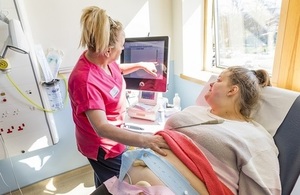 A nurse doing health checks on a pregnant woman.