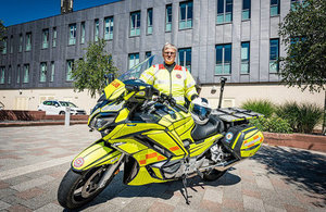 Gareth Cresswell from the Blood bikes Cumbria standing beside a blood bike