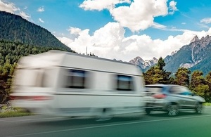 Image of a caravan being towed by a car on a road