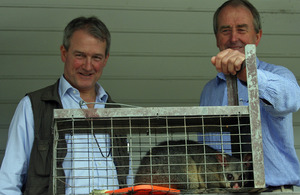 Owen Paterson and John Dalziel with trapped possum in foreground.