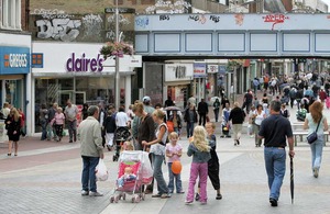 Mother with push chair standing in a high street