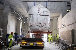 A large vessel being lifted in to the building by a crane