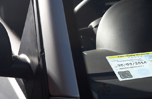 Blue badge on a car dashboard viewed through the windscreen