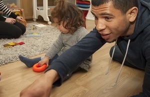 Child with nursery worker playing on floor