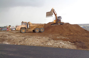 Construction works underway. Pictured is a digger and truck on top of a large pile of soil.
