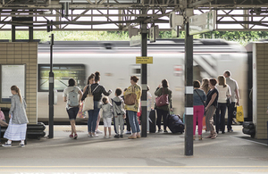 Group of rail passengers on platform with luggage as train arrives
