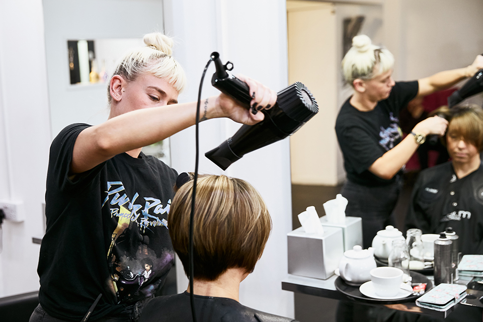 Hairdresser cutting a client's hair at the Hair Host salon.