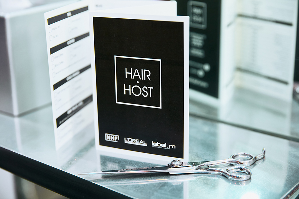 The Hair Host logo and scissors on a shelf.