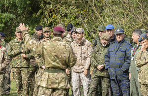 An Army colonel delivers a presentation to an international delegation of military inspectors
