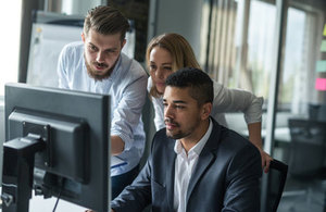 Photograph of people sitting around a desk in office