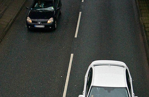 Aerial view of single carriageway road, 2 cars passing
