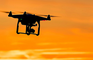 Drone silhouetted against sunlit sky