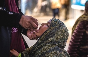 Woman in Afghanistan receives polio vaccination.