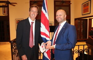 Gary Stempel junto al Embajador Potter sosteniendo el MBE