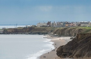 View from the England Coast Path looking at Seaham from the north. A long beach and a small settlement is visible.