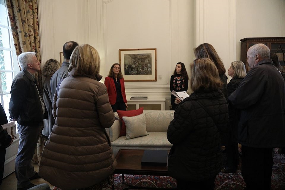 Visitors observing painting with curator and historian