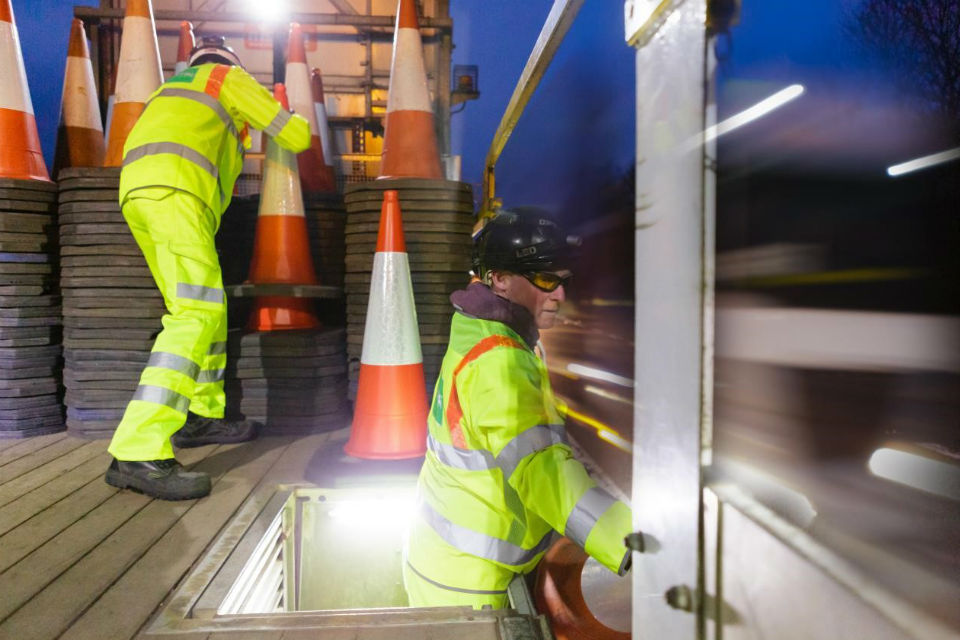 Highways England workers laying cones manually