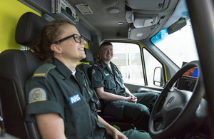 Two paramedics chatting and laughing in the front of an ambulance