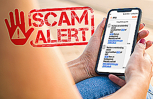 Hands holding a mobile phone with a scam text message on it