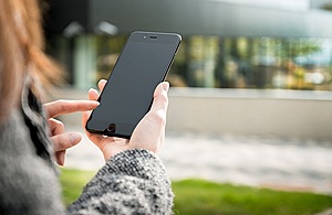 A woman stood out doors using a smartphone