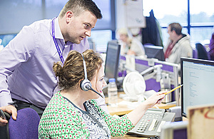 Two contact centre advisers looking at a computer