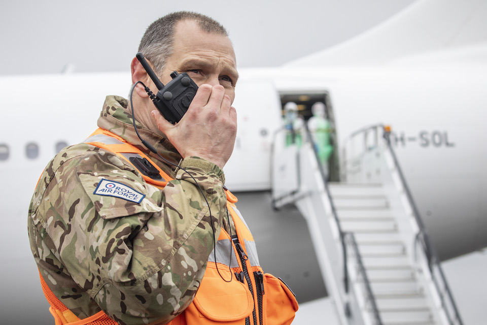 A member of Royal Air Force personnel speaks into a walkie talkie