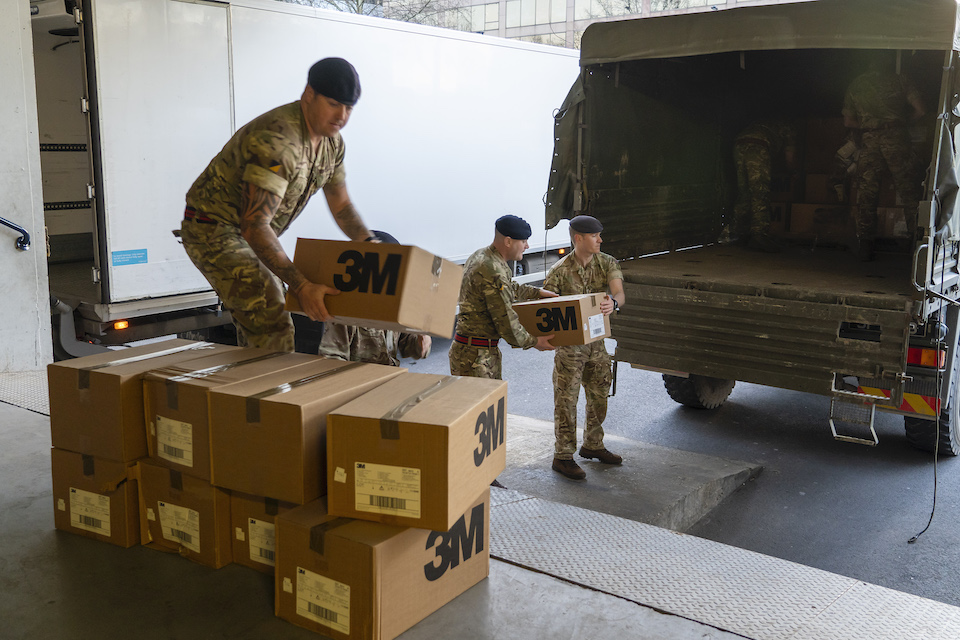 UK Armed Forces personnel moving boxes off of a lorry. MOD Crown Copyright. 