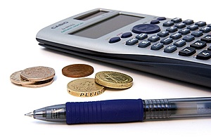 Calculator with loose coins and a pen