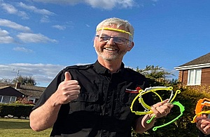 A photograph of Andy Ellison holding the 3D printed visors he has been making